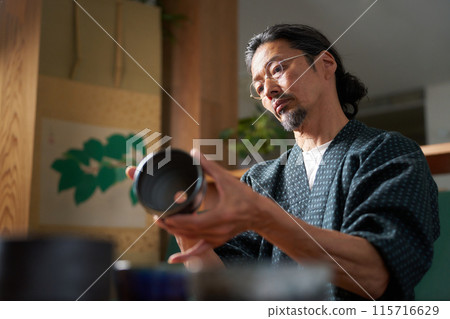 一個穿著日式服裝的男人看著陶瓷、陶藝家、鑑定師的形象 115716629