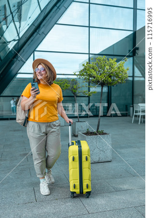 Young Caucasian female passenger in stylish casual clothes sit has training online meeting on laptop computer in airline lounge wait transit international airport. Young Caucasian female passenger in stylish casual clothes sit has training online meeting on laptop computer in airline lounge wait transit international airport. 115716995