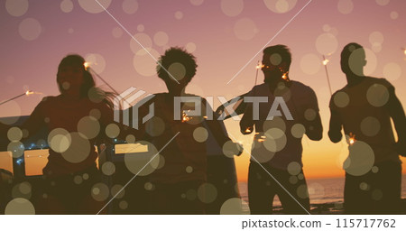 Image of yellow spots of light over friends dancing with new year sparklers on beach Image of yellow spots of light over friends dancing with new year sparklers on beach 115717762