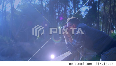Spots of light against caucasian male photographer clicking pictures with digital camera outdoors 115718748