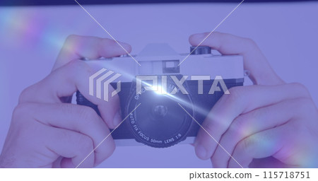 Spot of light against close up of hand holding a digital camera 115718751