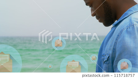 Image of mail icons over midsection of biracial man using smartphone at beach 115718757
