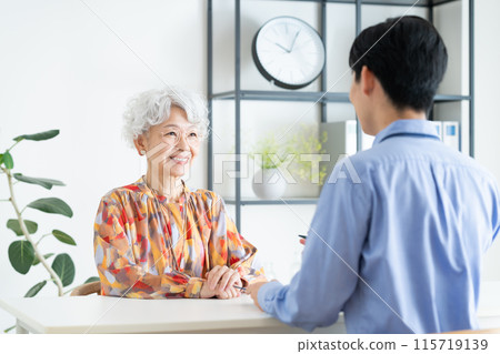 Senior woman consulting with planner Senior woman consulting with planner 115719139