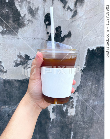 A close-up photo of a hand holding a mug of coffee A close-up photo of a hand holding a mug of coffee 115719902