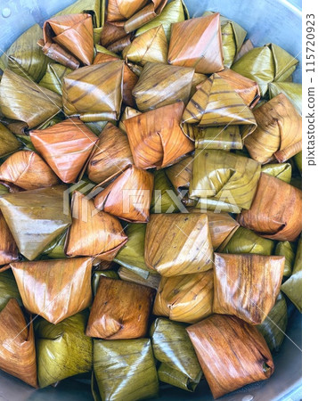 Delectable Thai desserts wrapped in vibrant green banana leaves. Delectable Thai desserts wrapped in vibrant green banana leaves. 115720923