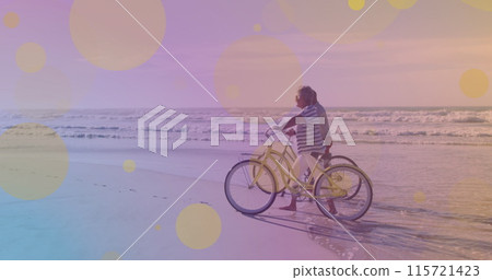 Senior couple celebrates Pedal Day at beach with bicycles. Senior couple celebrates Pedal Day at beach with bicycles. 115721423