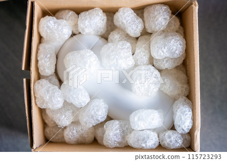 Eco packaging of parcels and white biodegradable filler. Box is filled with a filler safety for environment. Delivery of goods, parcels, delivery service, nature protection and recycling concept 115723293