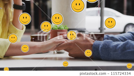 Image of digital emoji icons floating over caucasian couple holding hands 115724334