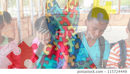 Image of puzzle pieces over diverse schoolchildren using tablet 115724449