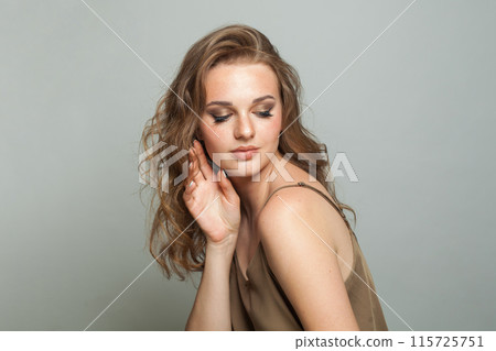 Female model face. Woman with makeup, curly hairstyle and fresh skin on white background Female model face. Woman with makeup, curly hairstyle and fresh skin on white background 115725751