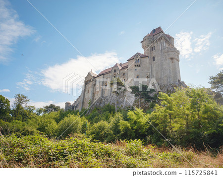 summer trip around Vienna, Austria. Liechtenstein Ancient castle from the 12th century. Historic castle on blue sky background. Liechtenstein, Lower Austria (Located near the Modling city) 115725841