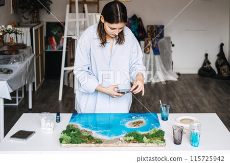 Artist Crafting an Epoxy Resin Landscape in Her Studio 115725942