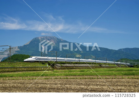 A bullet train running under clear skies with Mt. Ibuki in the background 115728325