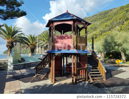 Riva Trigoso, Sestri Levante, Liguria, Italy, September 21, 2023: view of childrens playground in Riva Trigoso village with sea view, bench and palm trees at sunny day 115728372