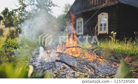 Burning branches outside the village house in eastern europe. 115728500