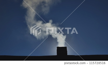 Silhouette of smoke against the sun from the chimney of a village house. Silhouette of smoke against the sun from the chimney of a village house. 115728516