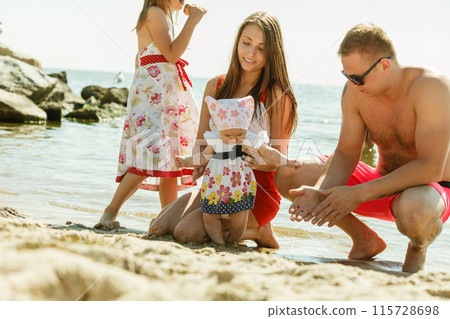 Family posing at beach near sea 115728698