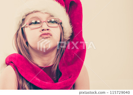Girl in santa hat making silly face Girl in santa hat making silly face 115729040