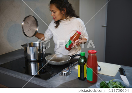 Woman preparing tomato sauce in modern kitchen 115730694