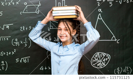 Schoolgirl fooling around playing with textbooks, stack of books on child's head Schoolgirl fooling around playing with textbooks, stack of books on child's head 115731125