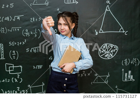 Schoolgirl girl shows her dissatisfaction with the school curriculum by putting her finger down Schoolgirl girl shows her dissatisfaction with the school curriculum by putting her finger down 115731127