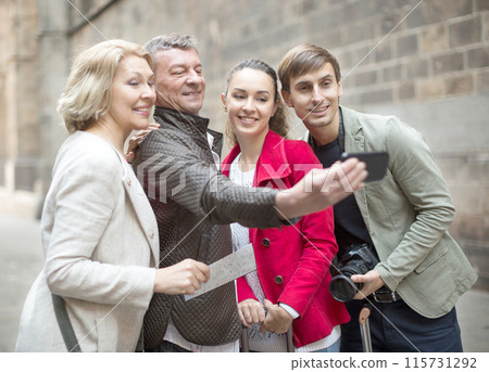 Tourists taking selfie on old street of European city 115731292