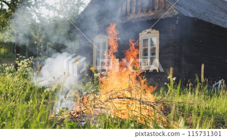 Burning branches outside the village house in eastern europe. 115731301