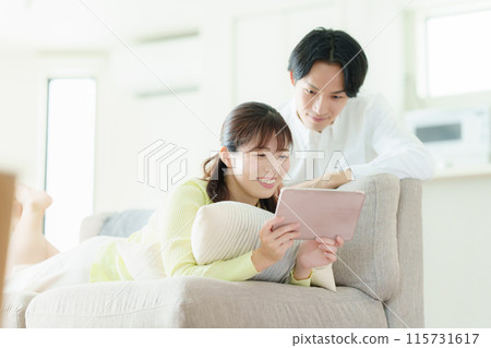 A couple looking at a tablet 115731617