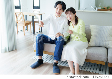 年輕夫妻在客廳看電視 115731635