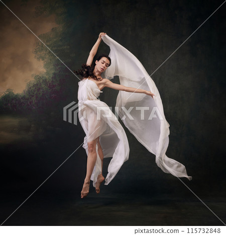 Draped in delicate fabric, dancer embodies lightness and fluidity in her movements against vintage studio background. Draped in delicate fabric, dancer embodies lightness and fluidity in her movements against vintage studio background. 115732848