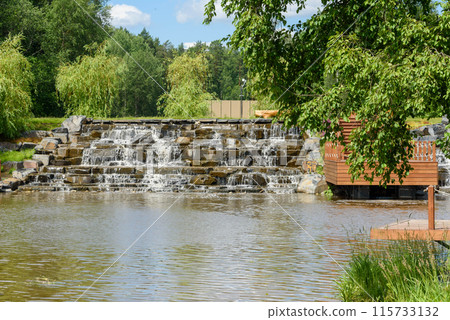 A cascade of an artificially created waterfall made of stone steps. 115733132