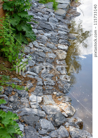 A secluded place on the shore of a lake, a beach lined with beautiful stones. 115733140