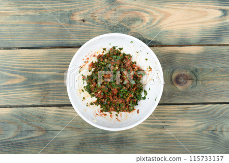 Top view of a white bowl of homemade gremolata seasoning. Top view of a white bowl of homemade gremolata seasoning. 115733157