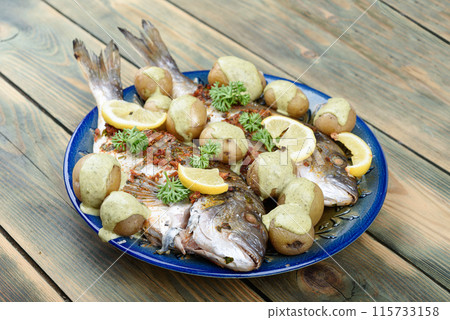 Dorado fish baked with gremolata seasoning and potatoes in cream sauce. Dorado fish baked with gremolata seasoning and potatoes in cream sauce. 115733158