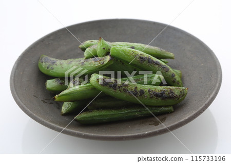 Grilled snap peas on a black plate, diagonal view Grilled snap peas on a black plate, diagonal view 115733196