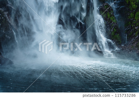 Moody waterfall flowing in tropical rainforest at Milford Sound Moody waterfall flowing in tropical rainforest at Milford Sound 115733286