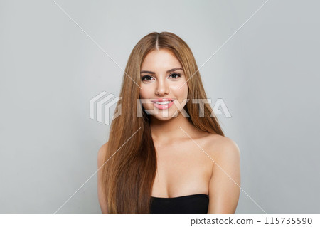 Glamorous woman with long hair and fresh clean skin studio portrait on grey background.  115735590