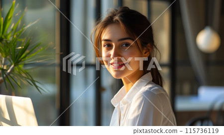 Professional Woman Smiling in Sunlit Office Professional Woman Smiling in Sunlit Office 115736119