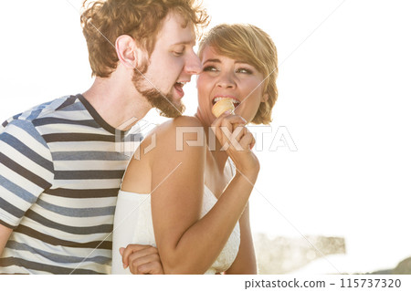 young couple eating ice cream outdoor young couple eating ice cream outdoor 115737320