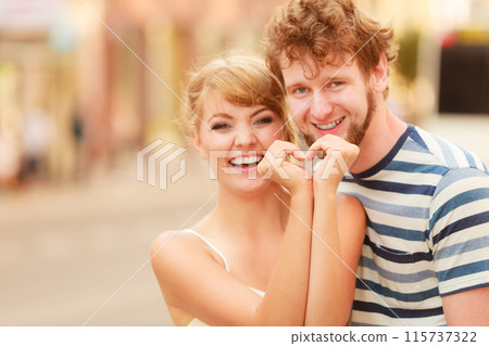 Couple on city street making heart shape by hands 115737322