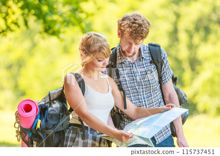 Hiking backpacking couple reading map on trip. 115737451