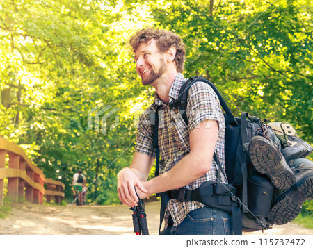 young man with backpack hiking in forest trail 115737472