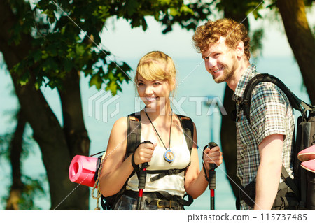 Two people tourists hiking by sea ocean. 115737485