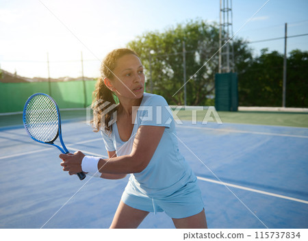 Woman playing tennis on outdoor court during daytime 115737834