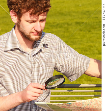 Tourist guy in city looking up directions on map Tourist guy in city looking up directions on map 115737963