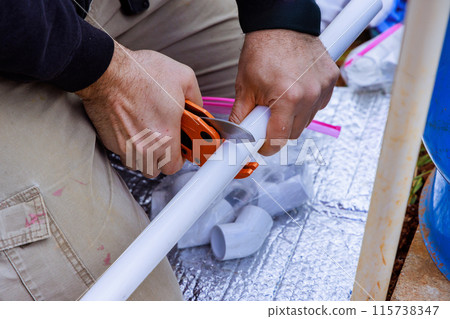 Plumber uses special scissors when installing plastic PVC water pipes Plumber uses special scissors when installing plastic PVC water pipes 115738347