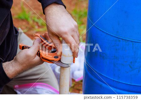 In course of installing water pipes, plumbers use special scissors to cut PVC pipe In course of installing water pipes, plumbers use special scissors to cut PVC pipe 115738359