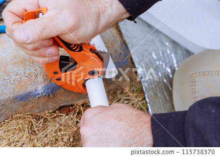 When installing water pipe, plumber cuts plastic PVC pipe with special scissors When installing water pipe, plumber cuts plastic PVC pipe with special scissors 115738370