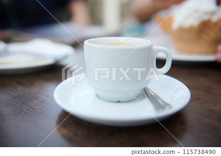 Close-up of coffee cup on wooden table in a cafe 115738490