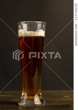 dark beer in a glass glass, fresh dark alcoholic beer dark beer in a glass glass, fresh dark alcoholic beer 115739250